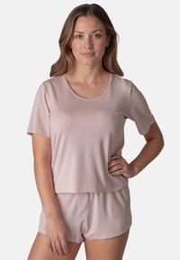 Top scurt de culoare roz deschis, cu guler rotund, asortat cu pantaloni scurți de aceeași culoare. Material moale, neted, cu o croială lejeră și cusături minime.
