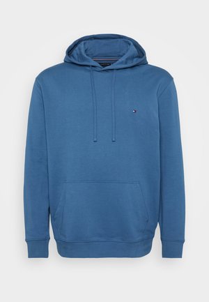 Modrá bavlnená mikina s kapucňou na šnúrku, klokanou vreckom a rebrovanými manžetami. Obsahuje malé logo na hrudi a hladký povrch.