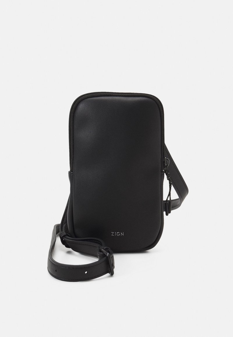 Petit sac bandoulière rectangulaire noir avec fermeture éclair, sangle réglable et logo "ZIGN" sur le devant.