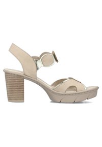 Sandale beige à bout ouvert avec talon épais empilé, bride de cheville réglable avec grande boucle et semelle en caoutchouc texturée.