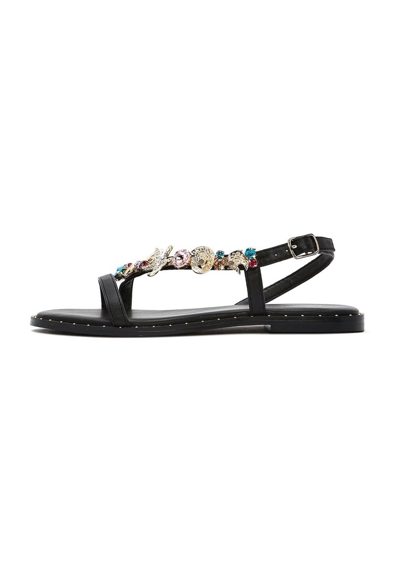Sandali in pelle nera con accenti floreali e metallici sulla parte superiore, dotati di una cintura con fibbia e una suola piatta decorata con borchie.