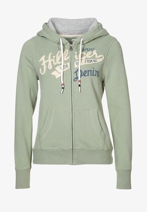 Zelená mikina s kapucí na zip z měkké tkaniny, s šedým vnitřkem, předními kapsami a vytištěným textem v krémové a námořnické modři. Ozdobená stahovacími šňůrkami.