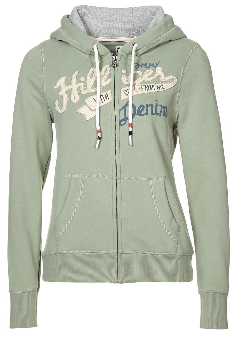 Zelená mikina s kapucí na zip z měkké tkaniny, s šedým vnitřkem, předními kapsami a vytištěným textem v krémové a námořnické modři. Ozdobená stahovacími šňůrkami.