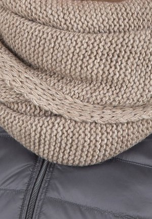 Écharpe beige en maille à infinity avec un motif texturé et épais, superposée sur une doudoune gris foncé avec un détail de fermeture éclair.