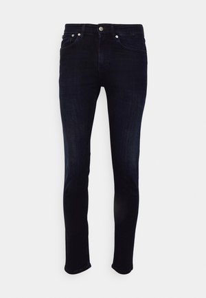 Jeans slim-fit de culoare albastră închisă, fabricate din denim, având talie medie, design cu cinci buzunare și cusături contrastante pe buzunare.