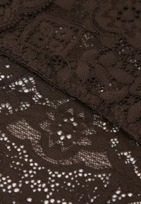 Braunes Spitzengewebe mit aufwendigen Blumenmustern, unterschiedlichen Texturen und ausgeschnittenen Details, die über einem einfarbigen braunen Hintergrund angeordnet sind.