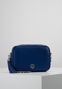 Borsa a tracolla in pelle blu con forma rettangolare, hardware in tonalità argento e accentuazione con nappine. Dotata di chiusura con zip e logo.