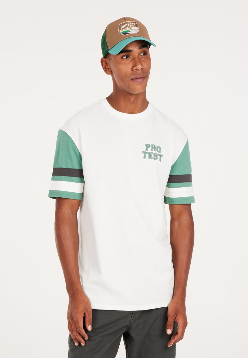 Witte t-shirt met korte mouwen en groene patroonsleeves, voorzien van een 'PRO TEST' grafiek op de borst. Draag het met een bruine en teal honkbalpet.