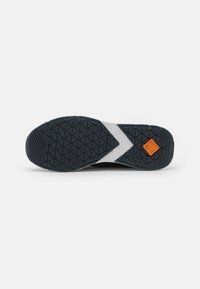 Black athletic shoe sole with a textured surface, white stripes, and an orange logo on one side. Shapes include diamonds and zigzags.