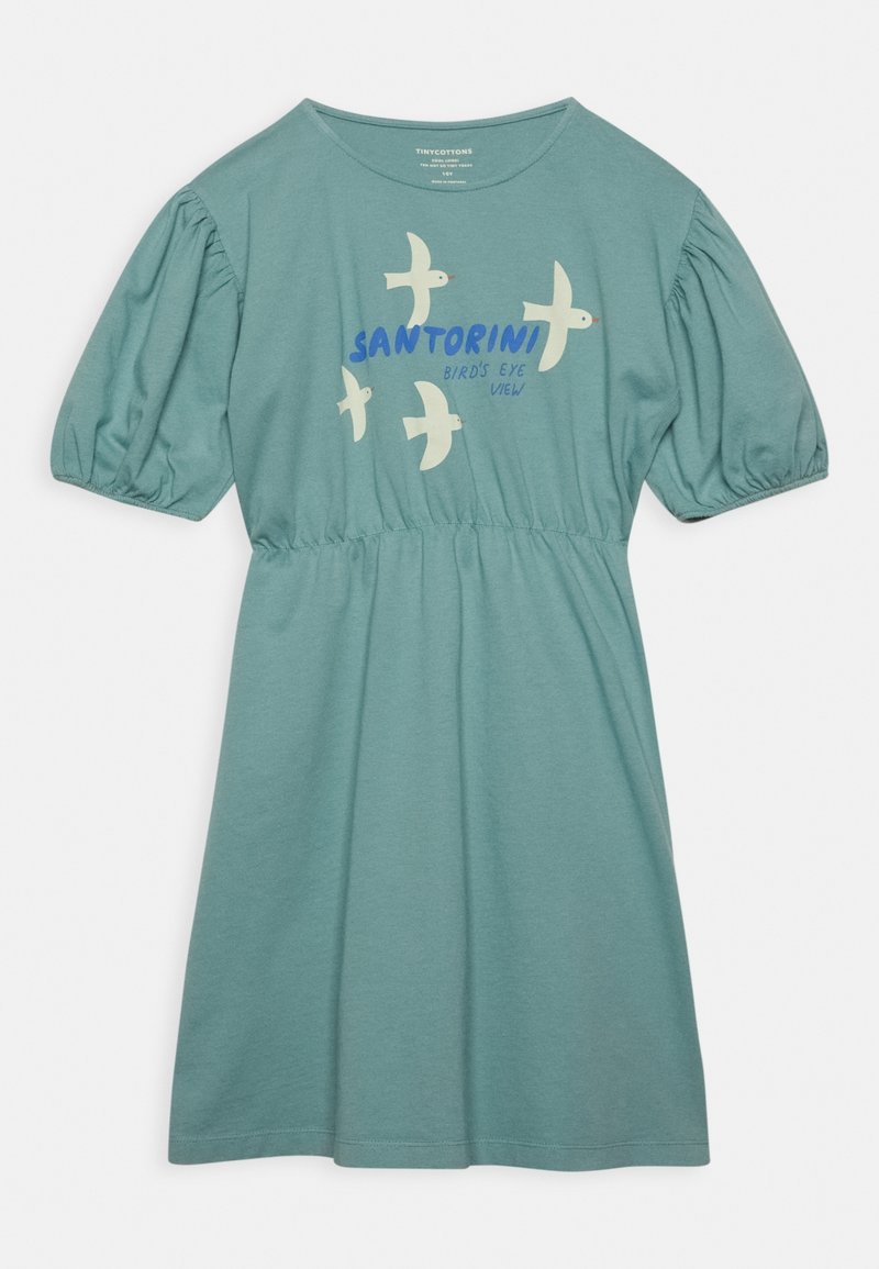 Robe en coton bleu sarcelle clair avec manches courtes bouffantes, taille froncée et un imprimé graphique d'oiseaux avec le texte « SANTORINI BIRD'S EYE VIEW ».