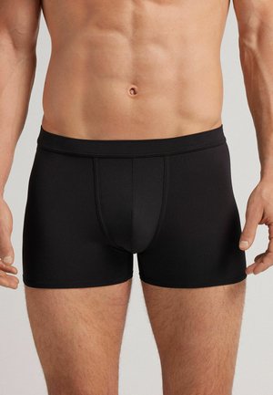 Schwarze Boxer-Briefs aus glattem, dehnbarem Stoff. Sie verfügen über ein enganliegendes Design mit einer unterstützenden Fronttasche und einem elastischen Bund.