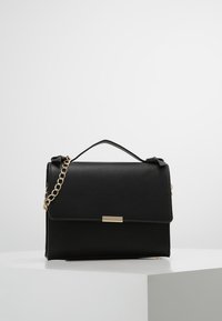Černá kožená kabelka s pevným tvarem, zlatým řetízkovým popruhem a přední klopou s kovovým akcentem. Hladká textura, elegantní provedení.