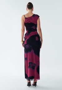 Bezruké, priliehavé šaty v čiernej a vínovej farbe s kvetinovým vzorom, s nariaseným dizajnom a dĺžkou až po zem. Elegantná textúra a plynulosť.