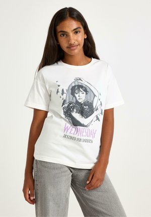 Hvid grafisk t-shirt med en sort-hvid illustration af en kvinde, med teksten "ONSDAG BESTEMT TIL MØRKE" i lilla.