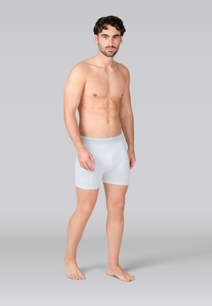 Valged puuvillased bokserpüksid pehme elastse vöökohaga, millel on helesinised detailid. Sile tekstuur ja liibuv disain.