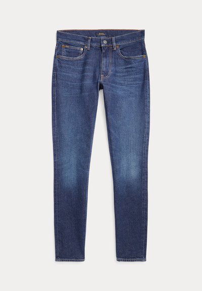 Tmavomodré úzke rifle s klasickým päťvreckovým dizajnom a zapínaním na gombíky, položené na bielom pozadí.