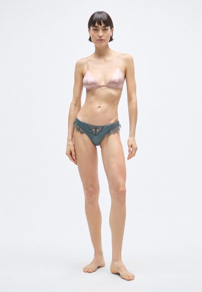 Ljusrosa satin trekantsbehå med tunna axelband, ihop med teal-färgade trosor med spetskant och blommönster längs kanterna.