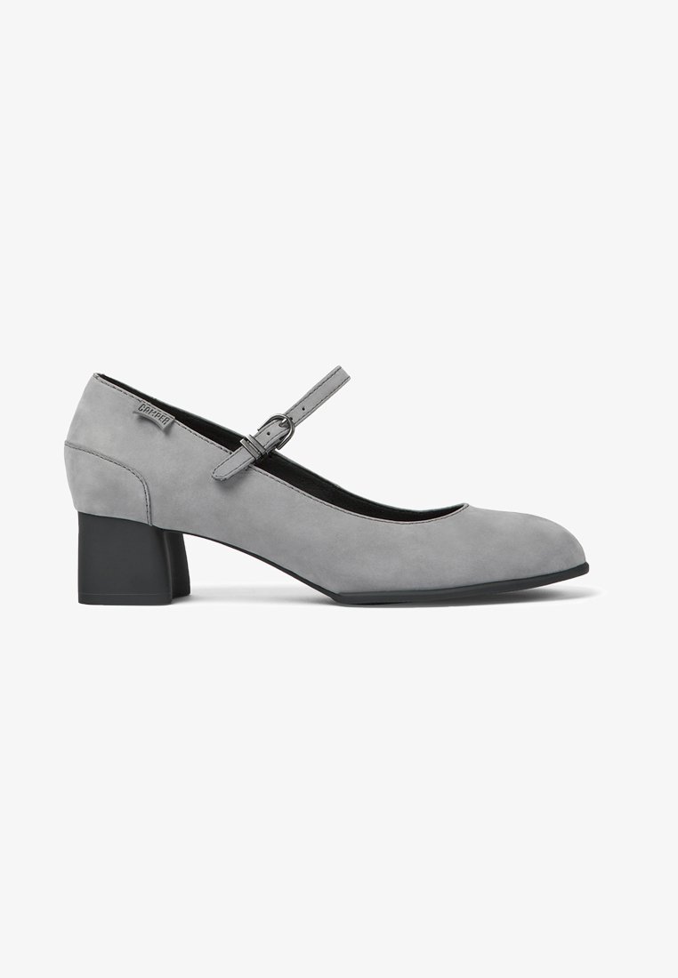 Gray suede Mary Jane shoe with a round toe, adjustable ankle strap, and a block heel. Textured upper and smooth sole detail.