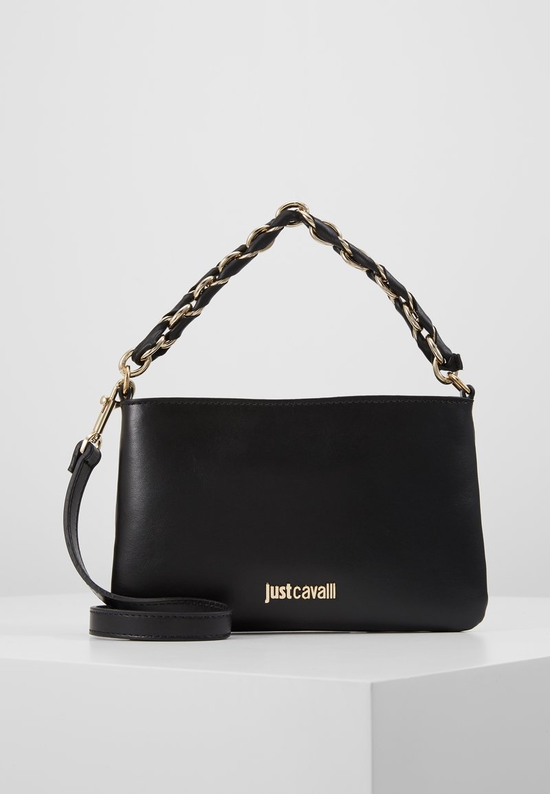 Svart läder axelväska med guldkedja och läderflätat handtag, guld "Just Cavalli"-logotyp på framsidan, vilande på en vit yta.