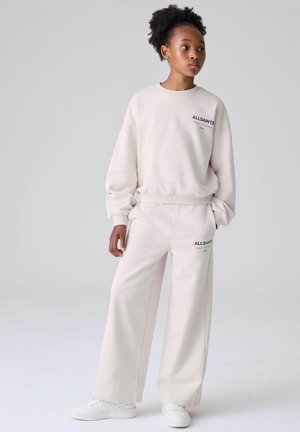 Lichtroze sweatshirt en bijpassende broek met wijde pijpen, voorzien van het zwarte "ALLSAINTS" logo. Gemaakt van zachte stof met geribbelde manchetten en tailleband.