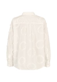 White blouse featuring embroidered circular patterns, soft texture, long sleeves, and a classic collar with button closure at the cuffs.
