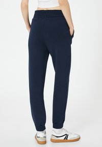 Marine joggers met een uitgerekte tailleband, zijzakken en elastische boorden. Gemaakt van een zachte stof, ontworpen voor comfort en bewegingsgemak.