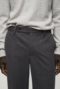 Grau Wollhosen mit glatter Textur, flachem Frontdesign und einem einzelnen Knopfverschluss, kombiniert mit einem hellgrauen Pullover.