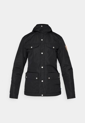 Black insulated jacket with a high collar, snap buttons, two chest pockets, two side pockets, and a leather accent on the sleeve.