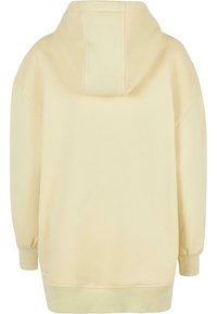 Przesadnie duża, jasnoprzepalowa bluza z długimi rękawami, ściągaczami u mankietów i kapturem, pokazana od tyłu na białym tle.