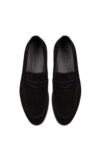 Mocassins en suède noir avec une sangle avant, des détails cousus et un intérieur lisse, avec une conception de bout arrondi et plat.