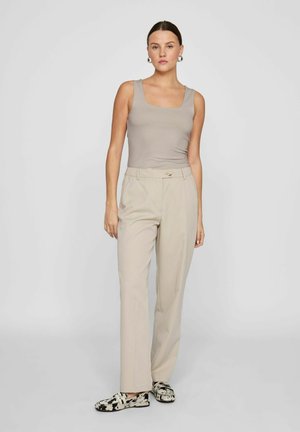 Beige tailored trousers with a button closure, paired with a light taupe fitted tank top. Features a square neckline and plain texture.