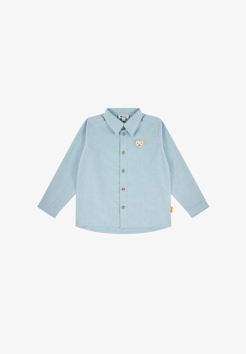 Camisa de manga larga azul clara con botón en el frente, cuello puntiagudo y bordado de un pequeño oso en el pecho. Tejido suave y dobladillo curvado.