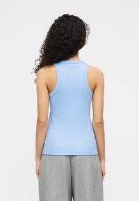 Ανοιχτό μπλε αμάνικο τοπ μ ε εφαρμοστό σχέδιο, κατασκευασμένο από ελαστικό ύφασμα, με στρογγυλή λαιμόκοψη και απαλή υφή.