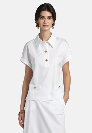 Bluza albă cu mâneci scurte și guler, cu o fâșie de nasturi și două buzunare frontale cu accente aurii. Textură netedă.