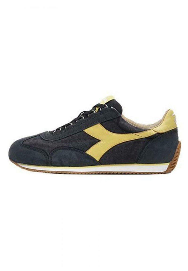 Scarpa sportiva nera e gialla con tomaia in suede e tessuto, caratterizzata da un grande logo giallo, suola intermedia bianca e suola in gomma testurizzata.