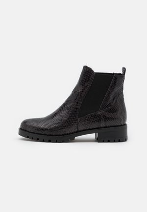Bottine noire avec texture effet cuir de serpent synthétique, empiècement latéral élastique, languette à la talon et semelle crantée épaisse.
