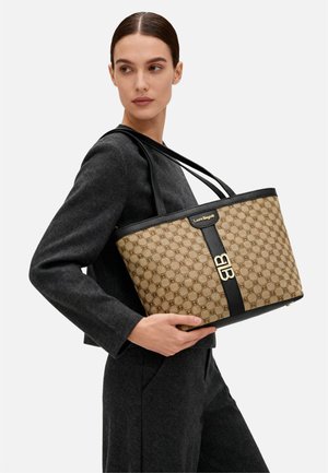 Borsa tote beige con motivo strutturato, dettagli in pelle nera e ferrature dorate. Dotata di manici lunghi per il trasporto.