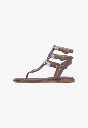 Purple flat sandal with three adjustable buckled straps and decorative iridescent gems along the T-strap and ankle area.