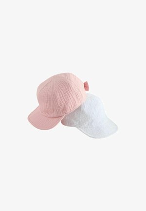 Soft textured pink cap with bow detail and white cap with floral eyelet pattern, both with curved brims, displayed on white background.