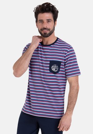 Homme portant un t-shirt à manches courtes rayé bleu, rouge et blanc avec une poche marine décorée d'un motif de vague.