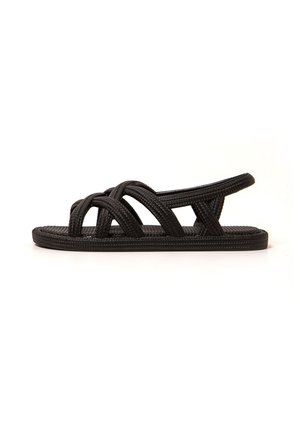 Sandalias negras de tejido con un diseño de espalda abierta, que cuentan con tiras entrelazadas, una suela plana y una plantilla texturizada para mayor agarre.
