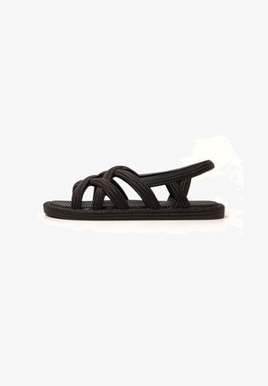 Sandalias negras de tejido con un diseño de espalda abierta, que cuentan con tiras entrelazadas, una suela plana y una plantilla texturizada para mayor agarre.