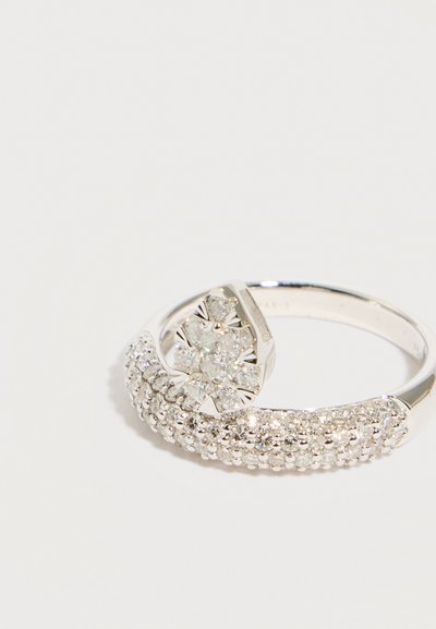 Ασημένιο δαχτυλίδι με στεφάνι από μικρά διαμάντια και ένα σύμπλεγμα μεγαλύτερων διαμαντιών διατεταγμένων σε σχήμα λουλουδιού στην κορυφή.