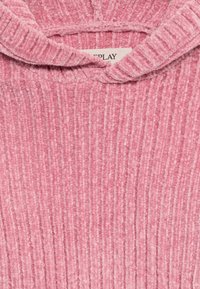 Suéter de punto acanalado de un suave color rosa con un cuello doblado, mostrando parte de una etiqueta de marca blanca en el cuello.