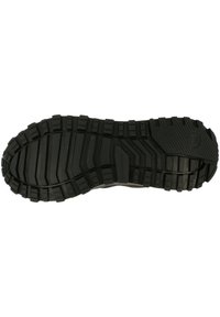 Svart gummiyttersula med djupa spår och räfflor för grepp, med en upphöjd logo på hälen och sömlösa kanter.