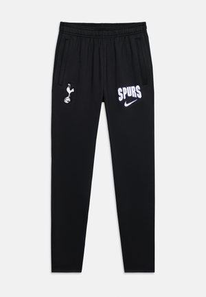 Pantalon de sport noir avec taille élastique, logo Tottenham Hotspur sur la cuisse gauche, texte "SPURS" et logo Nike sur la cuisse droite, poches latérales.