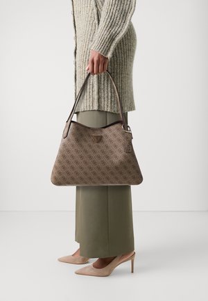Borsa a tracolla marrone con motivo, caratterizzata da una texture liscia, con un logo triangolare e un portachiavi staccabile; tenuta da una persona in un maglione chiaro e pantaloni verdi.