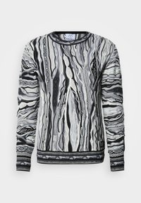 Pull en tricot noir, blanc et gris avec un motif en forme de vagues. Il présente un col rond, des manches longues et un tissu texturé avec des rayures contrastantes.
