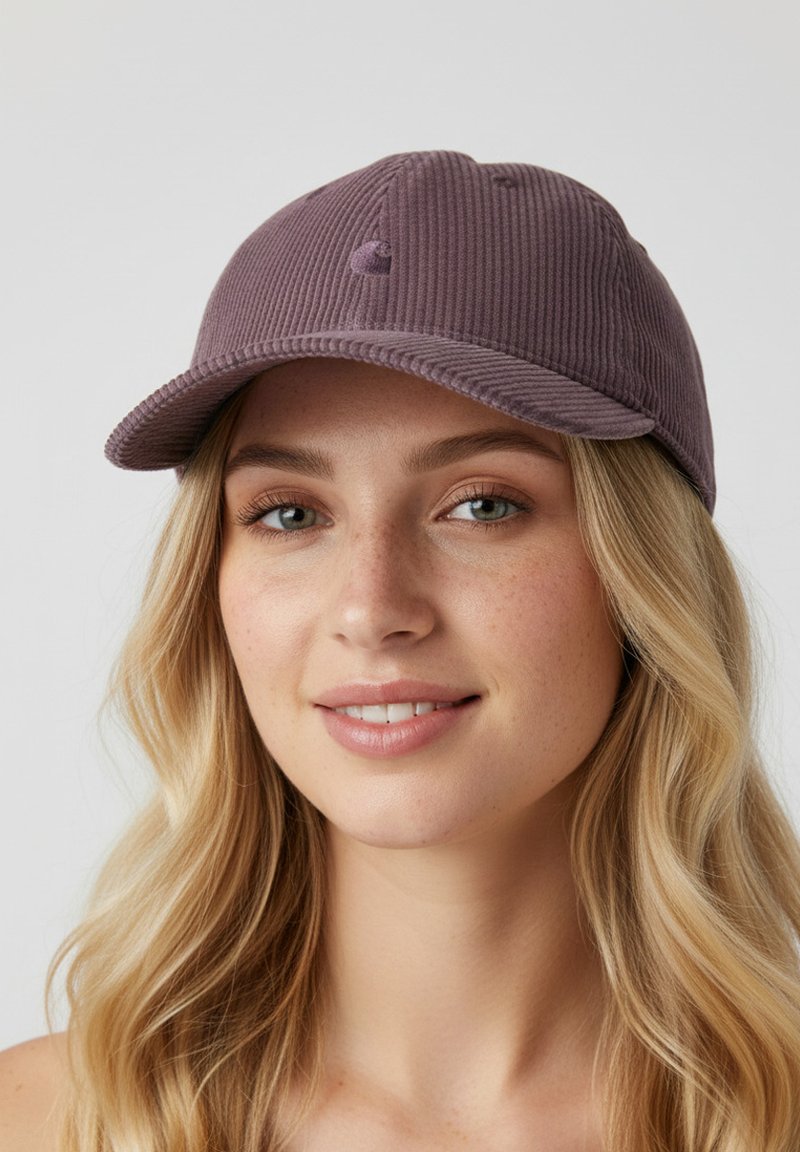 Casquette en velours côtelé violet avec une visière courbée et un logo brodé à l'avant. Présente une texture côtelée verticale et six œillets de ventilation.