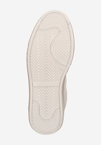 Light-colored shoe sole with a herringbone tread pattern, featuring circular and linear accents, made from flexible rubber material.